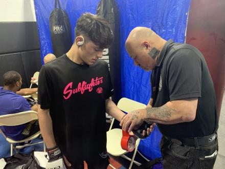 Inspector taping Sal's gloves